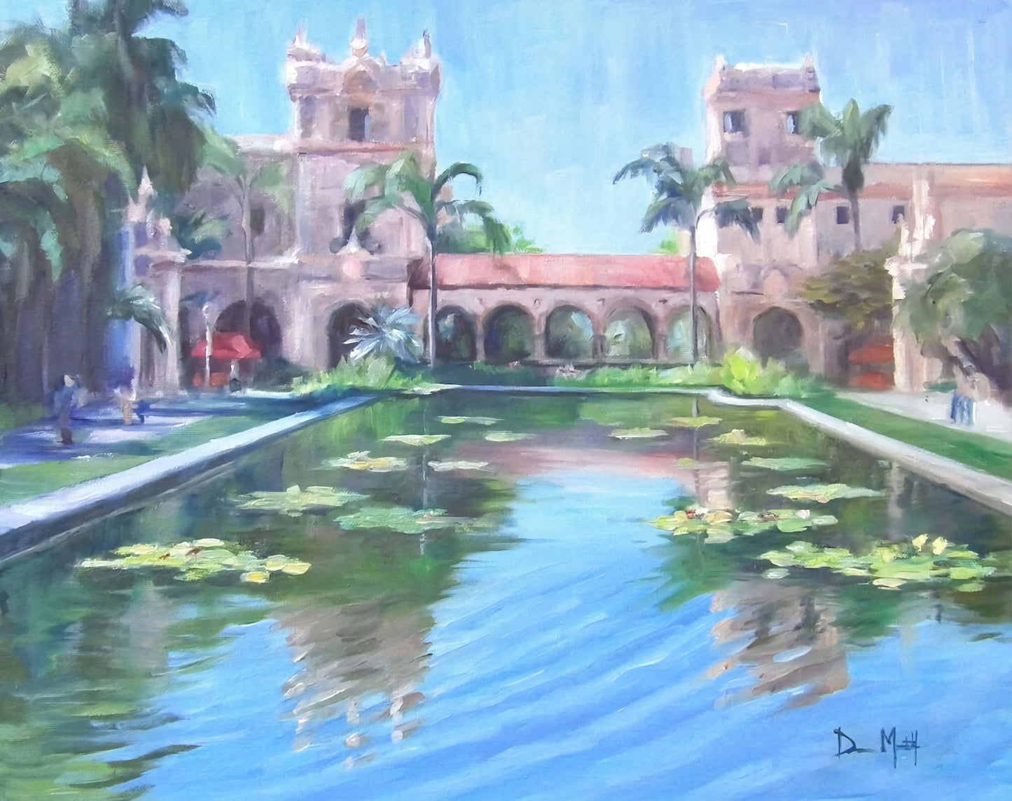 Reflecting pond with water lilies in front of pink buildings with Spanish architecture.